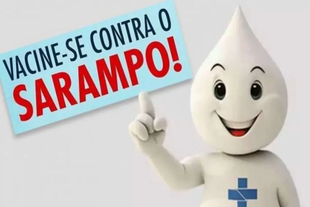 Mascote de vacinação de sarampo de desenho animado, um boneco sorridente apontando para a frase: "Vacine-se contra o Sarampo!".