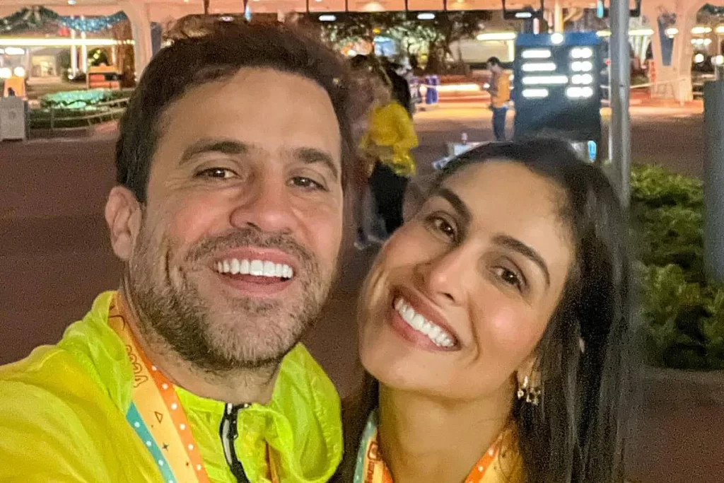 O empresário e coach Pablo Marçal e sua esposa sorrindo para a câmera em uma selfie noturna, em um parque temático.