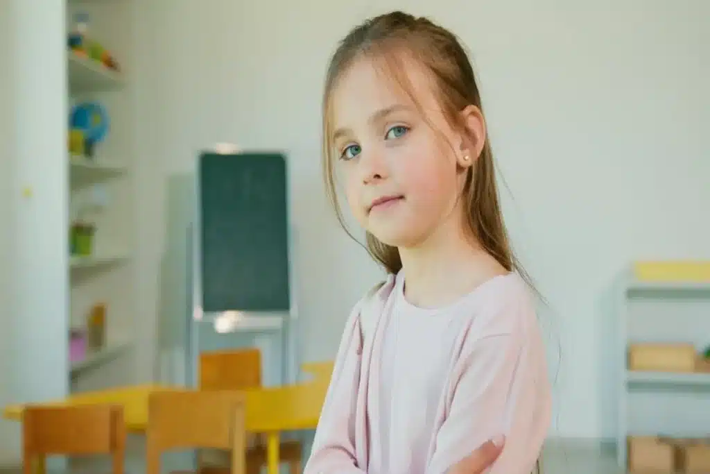 Retrato de uma aluna com cabelos longos e olhos azuis, em uma sala de aula, simbolizando a fase do Ensino Fundamental.  