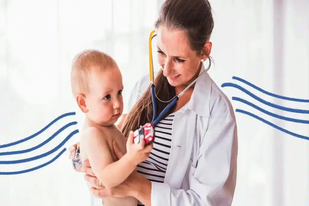 Uma médica pediatra com jaleco e estetoscópio examina um bebê em um consultório. A imagem representa o cuidado profissional e o diagnóstico de condições respiratórias como o VSR (Vírus Sincicial Respiratório).