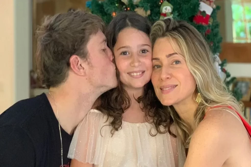 Leticia Spiller e seus filhos Pedro e Stella, abraçados em uma foto de família.