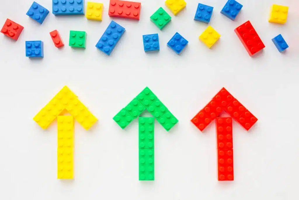 Blocos de montar de plástico formando setas, representando a criatividade em jogos de encaixe.