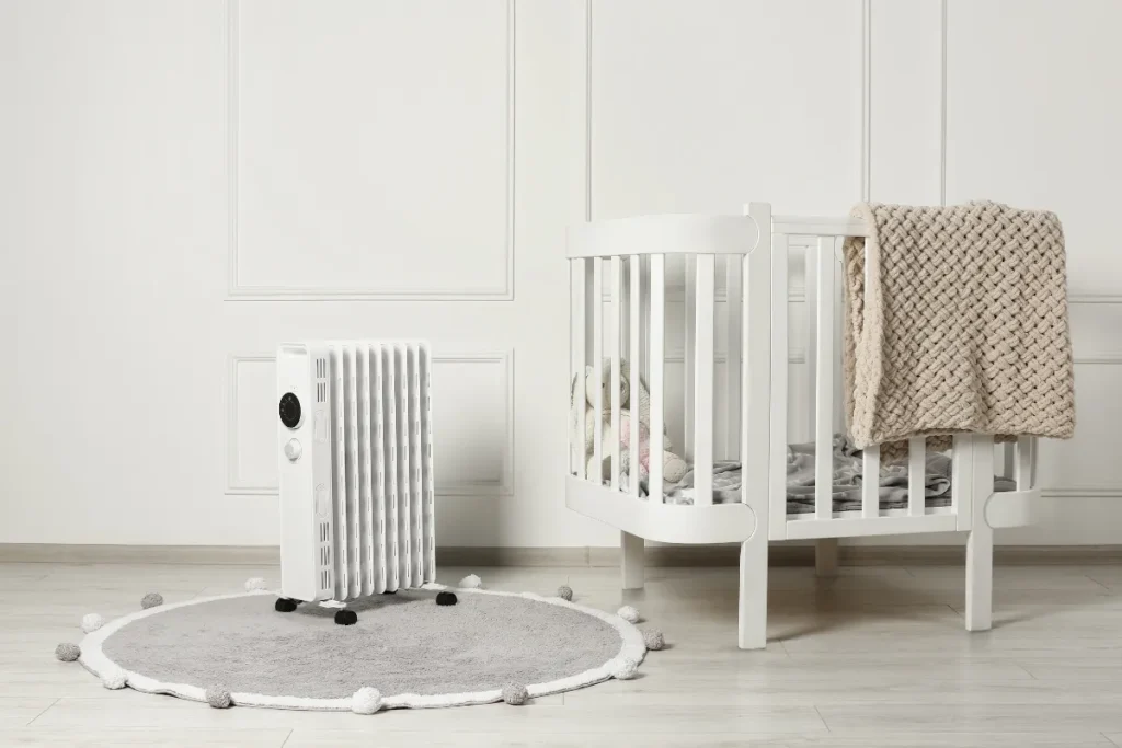 Berço infantil branco em quarto organizado com aquecedor próximo e ambiente preparado para conforto térmico
