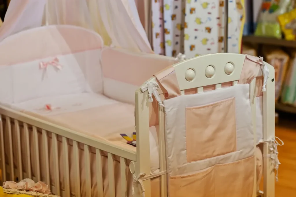 Berço infantil com colchão e proteção lateral em quarto decorado para rotina de sono do bebê.