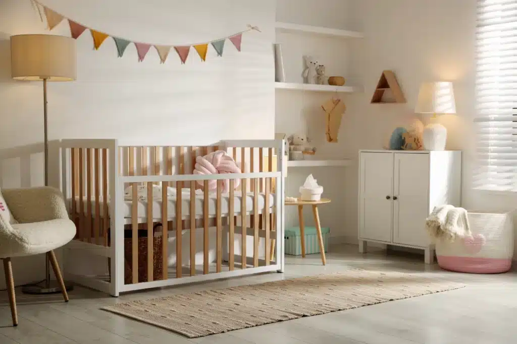 Quarto de bebê acolhedor com berço branco, tapete neutro e decoração delicada em estilo moderno.