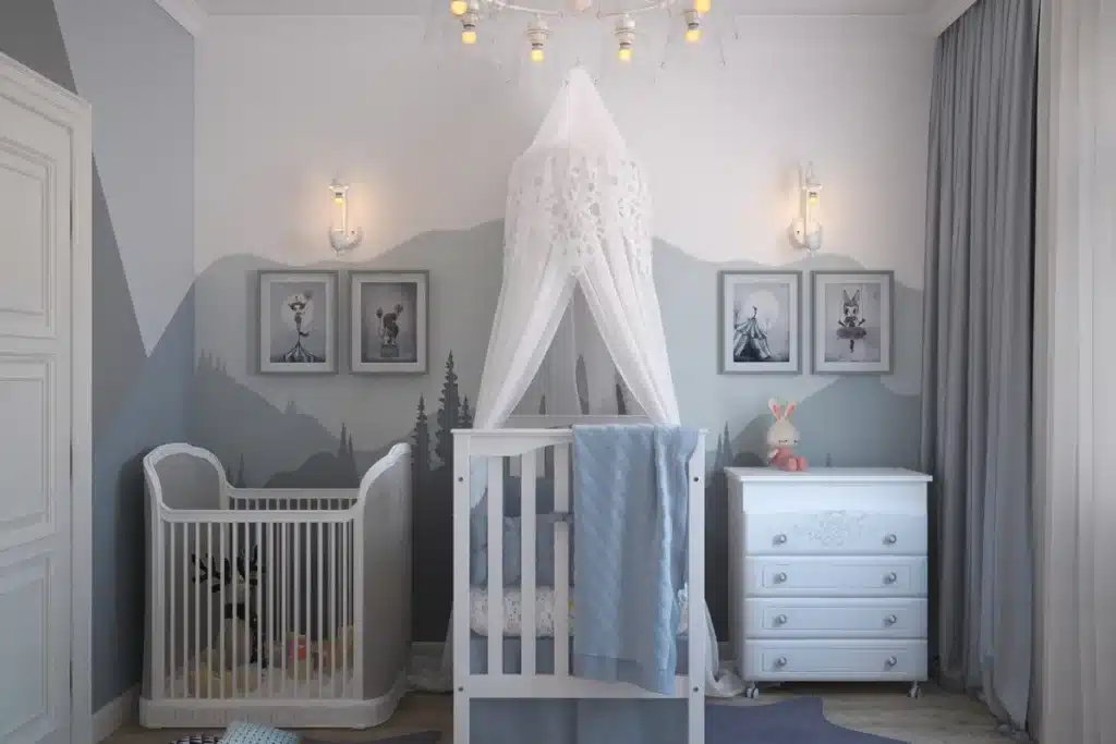 Quarto de bebê em tons cinza e branco com dossel decorativo, cômoda e iluminação aconchegante.