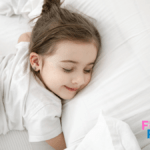 uma menina deitada de olhos fechados e sorrindo em uma cama branca
