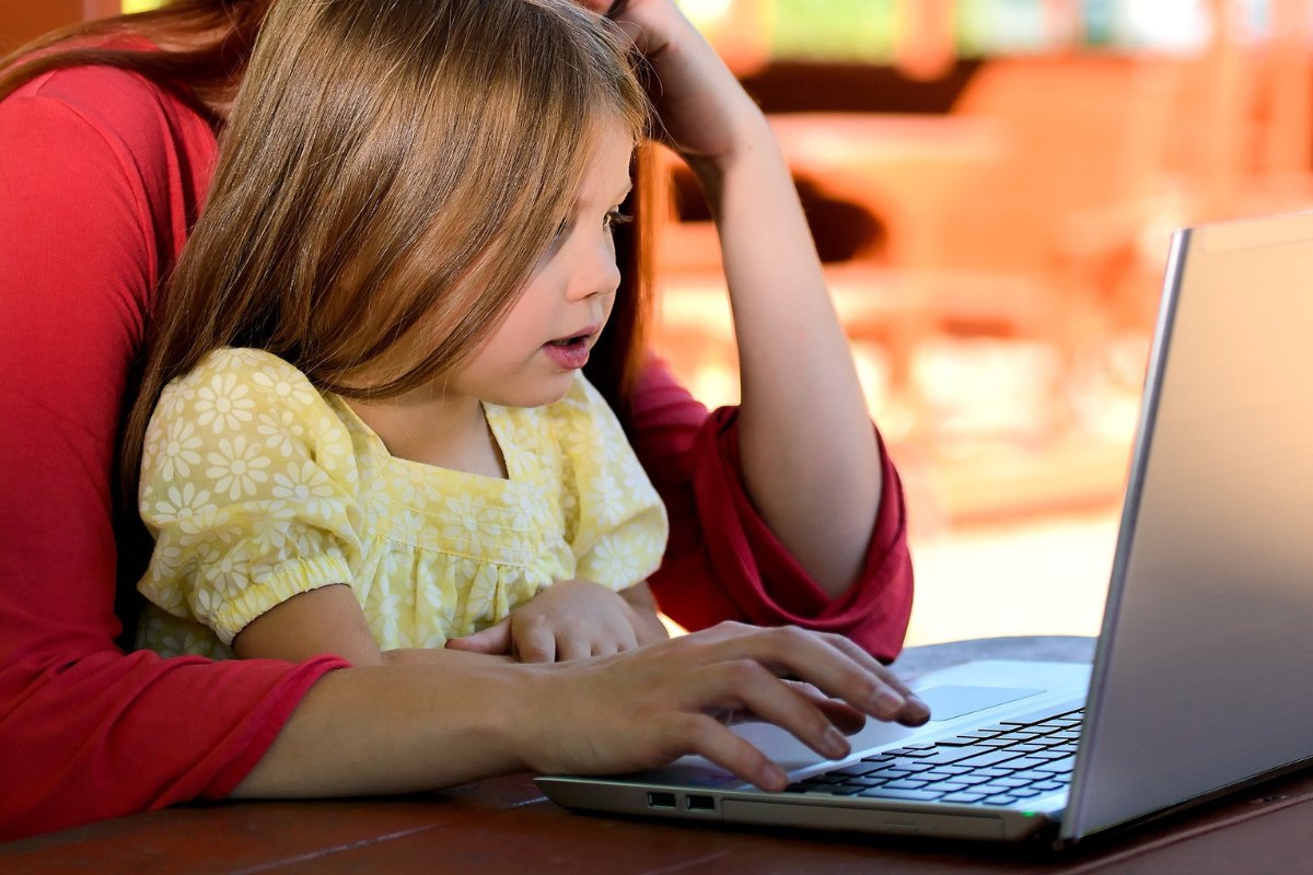 Dicas para o primeiro dia de aula: A imagem mostra uma mãe e uma criança no computador 