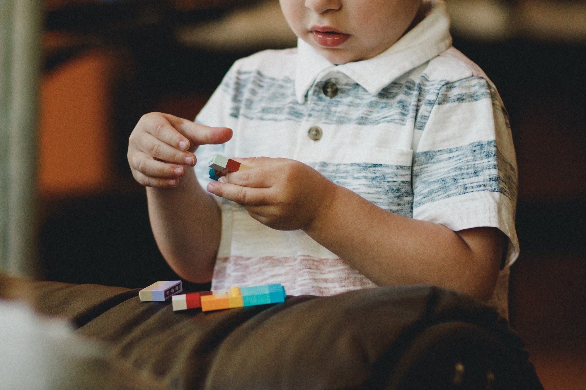 menino pequeno com peças de bloco de brinquedo nas mãos