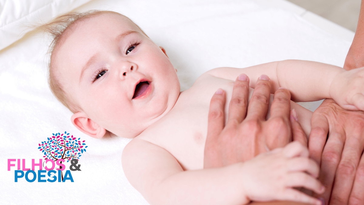 par de mãos massageando um bebê que sorri