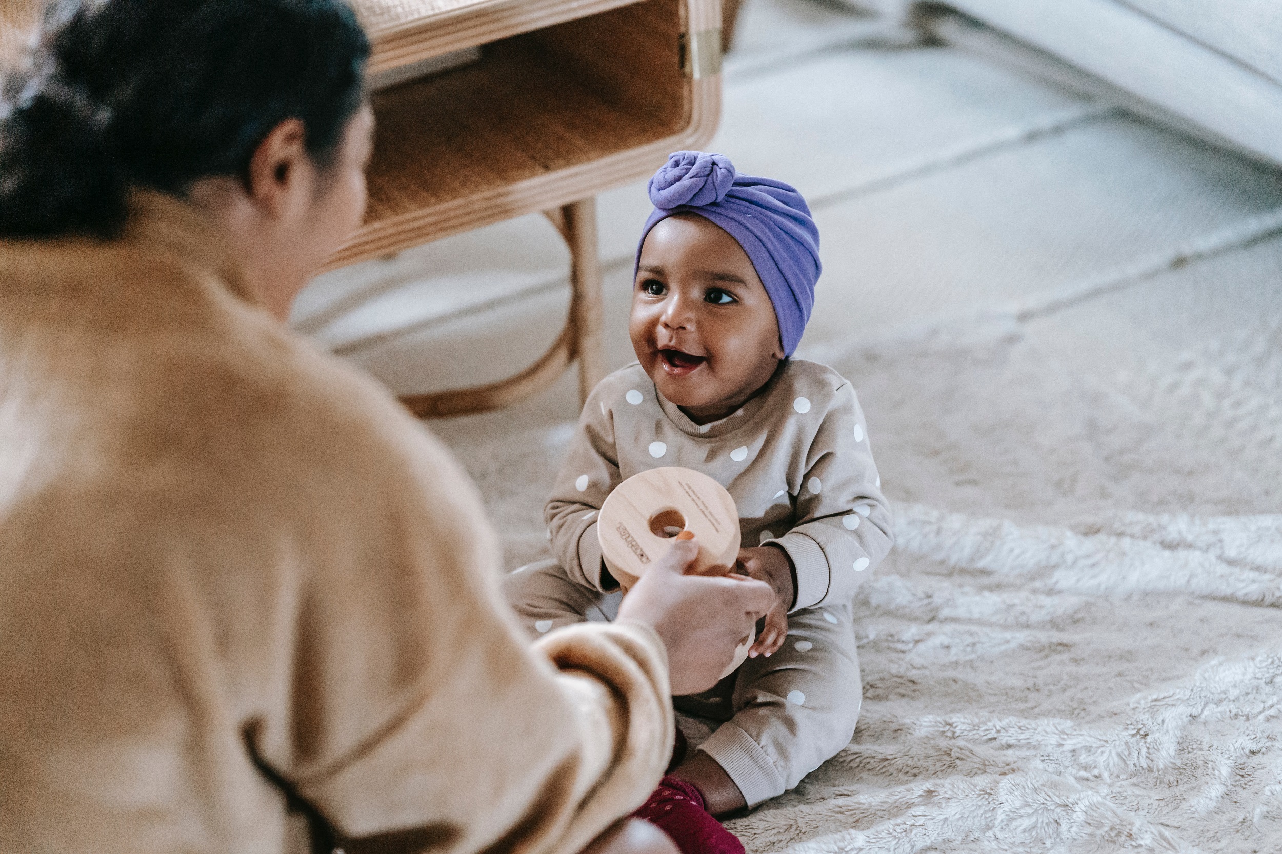 bebê negra feliz sorrindo sentada no chão brincando