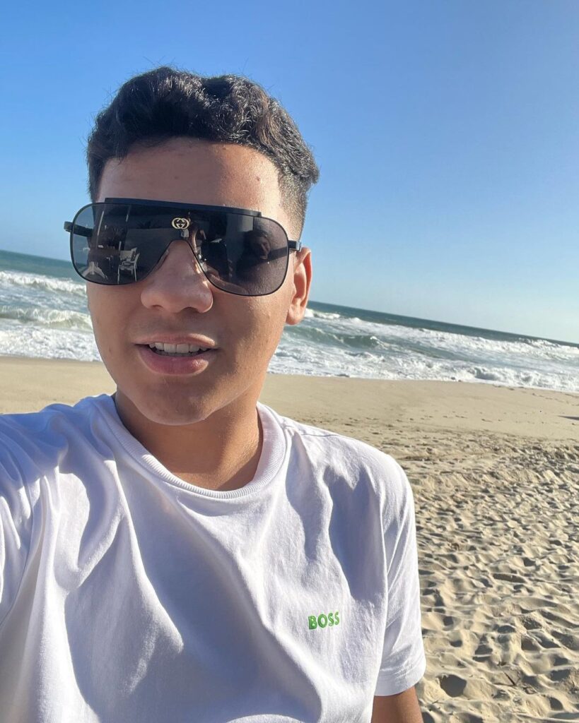 Foto de Kayky Bezerra na praia, filho de Deolane Bezerra