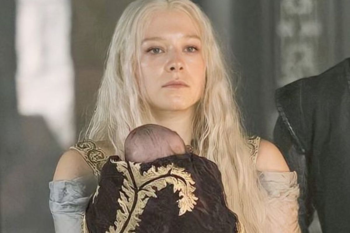 Personagem de Rhaenyra Targaryen segurando bebê no colo em cena de série