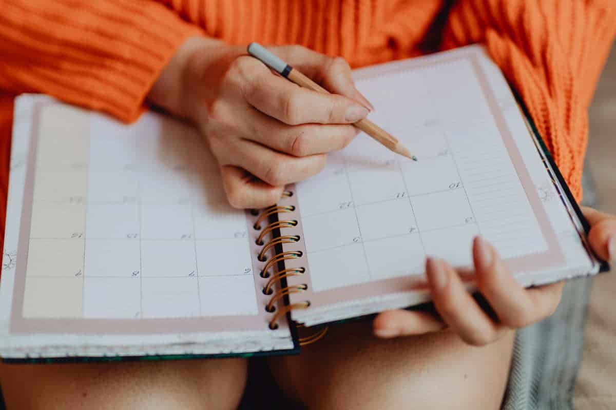 mulher anotando em um calendário de agenda