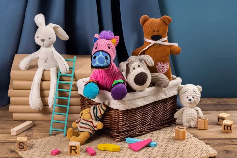 Brinquedos infantis como bichos de pelúcia, blocos de montar e livros empilhados organizados sobre tapete em ambiente lúdico e acolhedor.