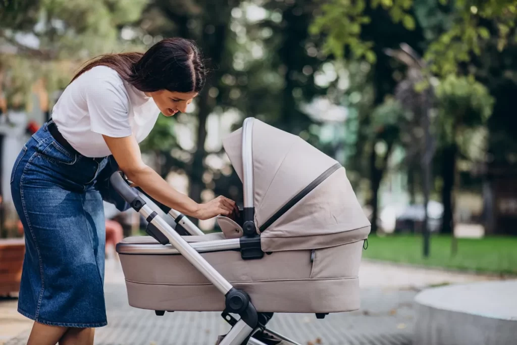 Mulher ajustando o carrinho de bebê em um parque durante um passeio ao ar livre