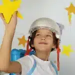 Menino com capacete brincando com uma estrela