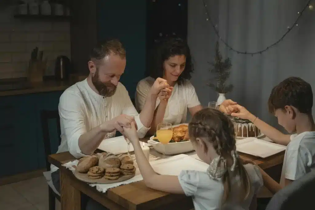 Casal e crianças de mãos dadas em oração