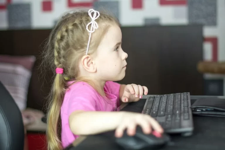 Menina usando computador com foco e atenção.