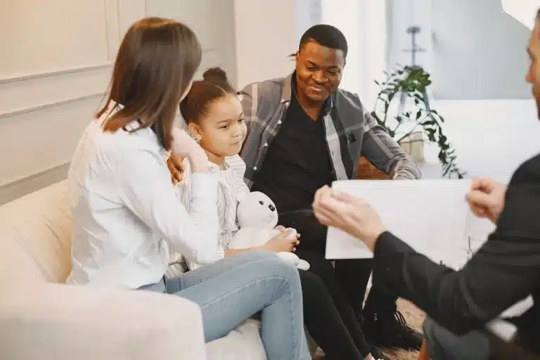 Família negra em sessão de terapia, psicólogo conversando com a família, terapia familiar com criança.