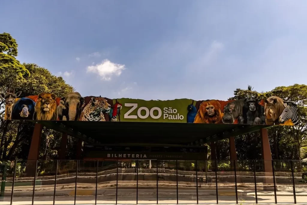 Entrada principal do Zoológico de São Paulo com letreiro colorido e imagens de animais.