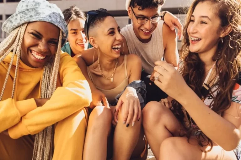 Grupo de jovens da Geração Z reunidos, sorrindo e conversando de forma descontraída, representando amizade, diversidade e conexão social.