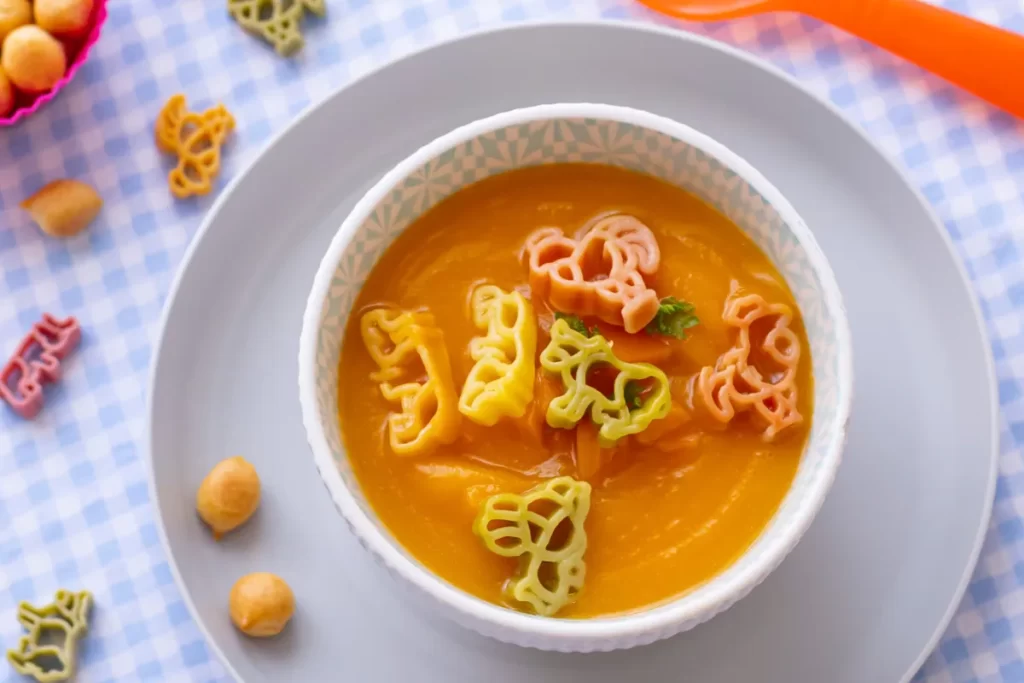 Sopa de legumes cremosa com massinha colorida em formato de animais.