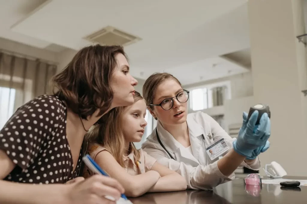 Fonoaudióloga explicando para mãe e filha sobre o desenvolvimento da fala e consciência fonológica