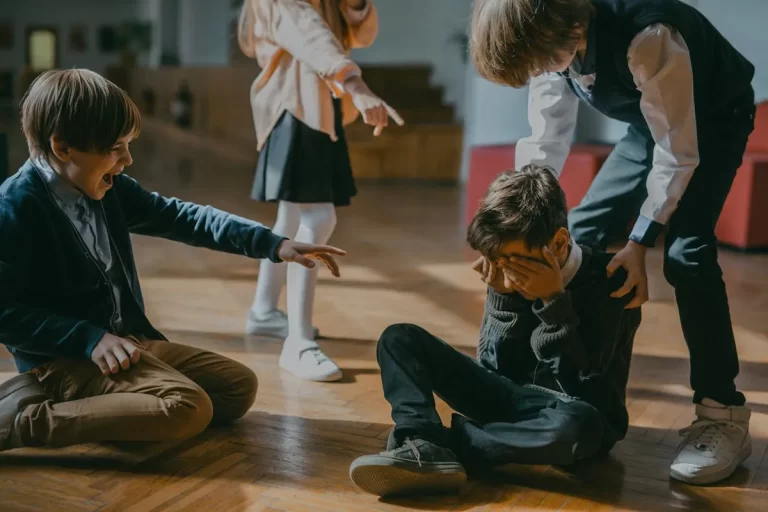 Criança sendo consolada após sofrer bullying na escola, representando a importância da psicologia escolar no acolhimento e prevenção
