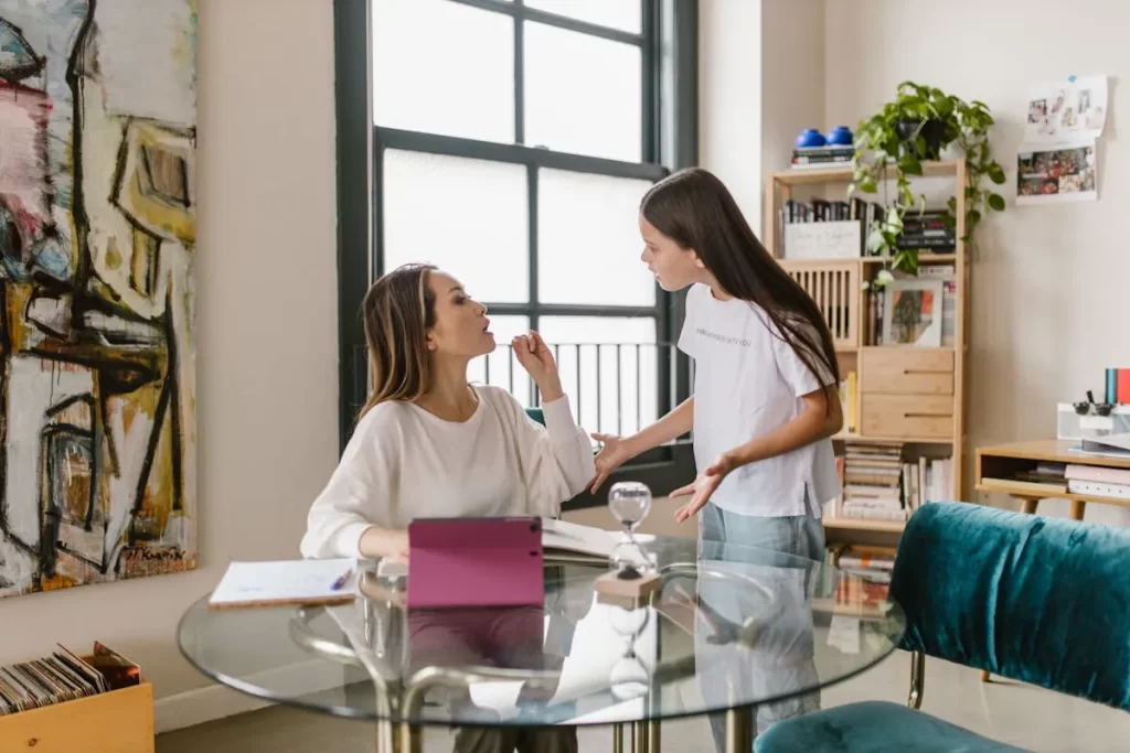 Mãe e filha conversando de forma séria em casa, representando os desafios emocionais da pré-adolescência