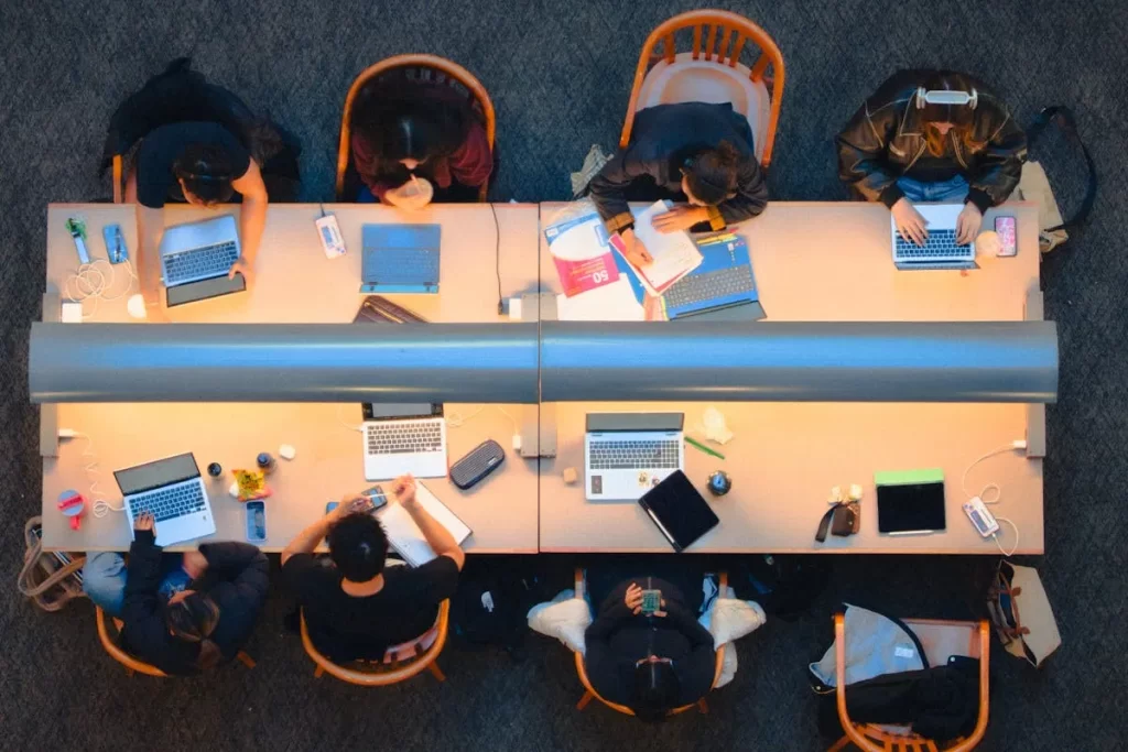 Grupo de estudantes utilizando notebooks em sala de aula, representando o aprendizado em escolas digitais