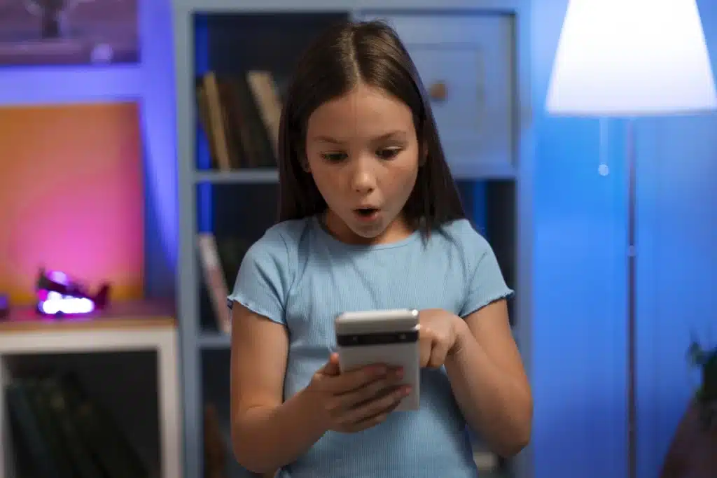 Criança olhando surpresa para o celular, simbolizando o uso do TikTok de crianças