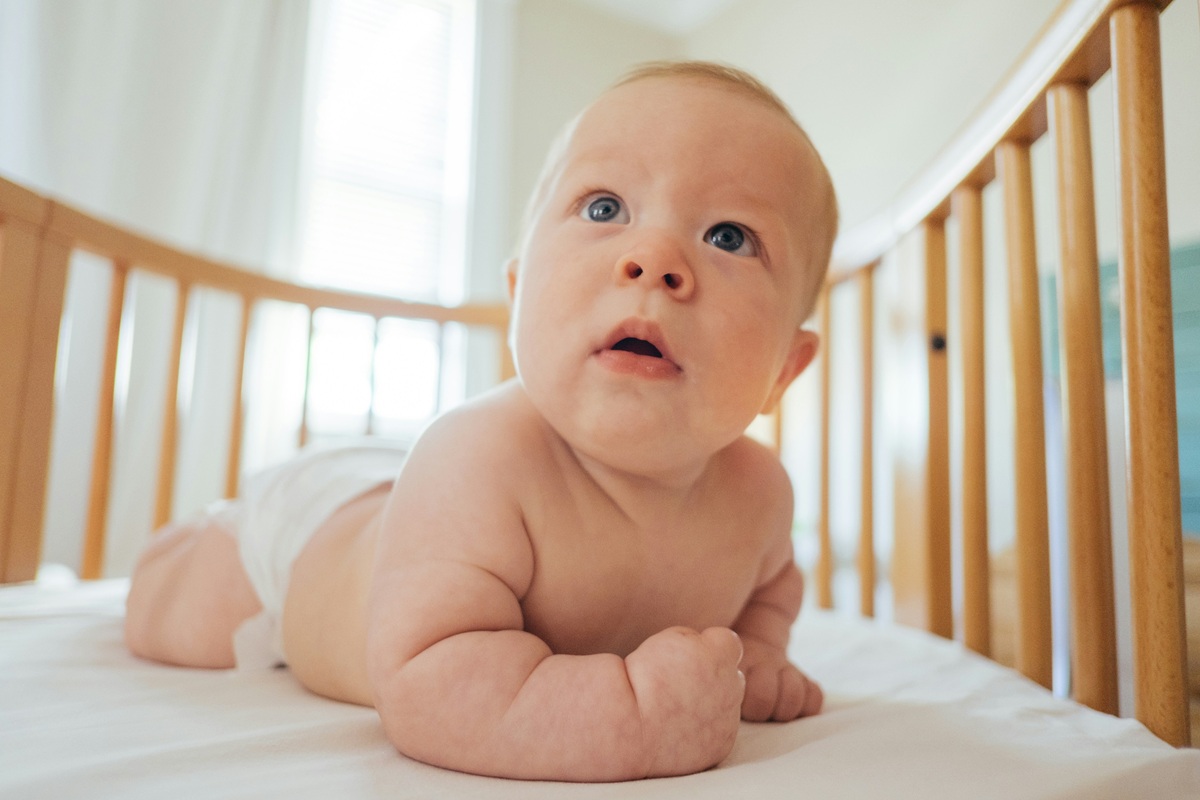 Bebê dentro de berço com grades em enquadramento simples