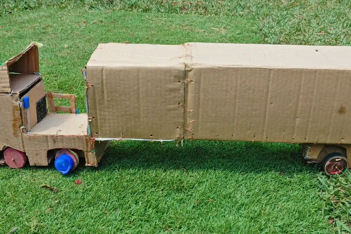 Caminhão de brinquedo artesanal construído com caixas de papelão e materiais reaproveitados