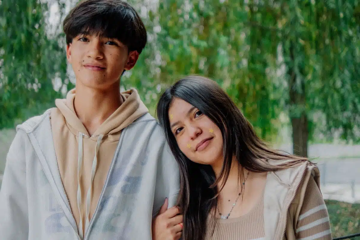 Dois adolescentes juntos em uma área externa arborizada